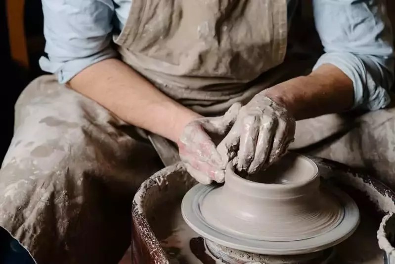 man making pottery on wheel