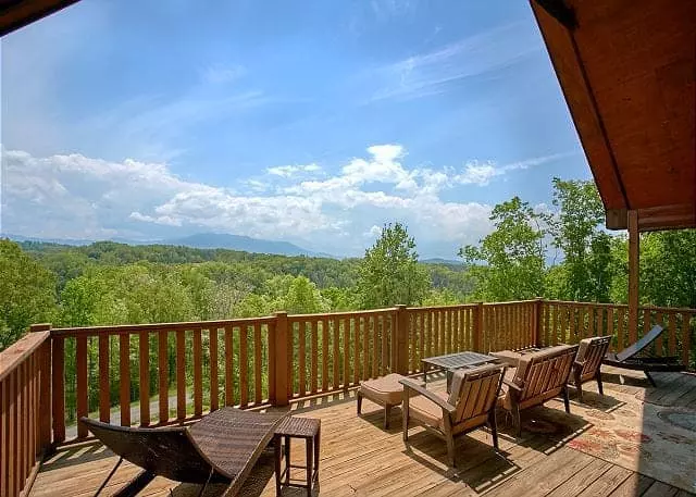 Chairs on the deck of a cabin with mountain views.