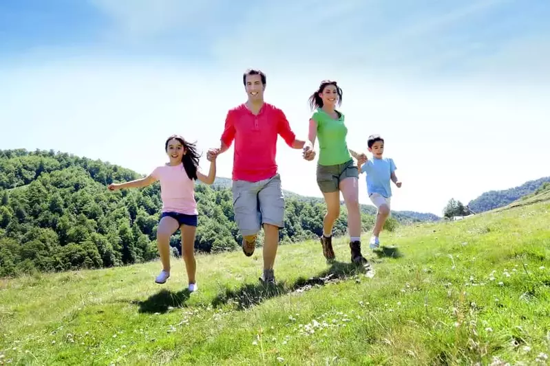 Happy family running outdoors enjoying one of the free things to do in the Smoky Mountains.