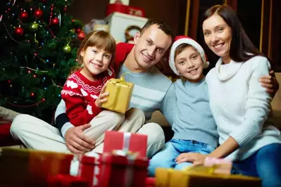 Family sitting around a Christmas tree