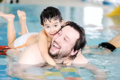 family playing in the pool