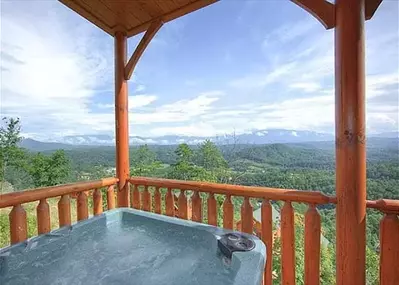 hot tub on the deck of a cabin in the mountains