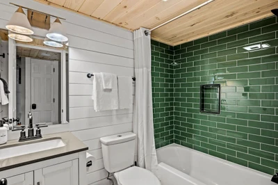 First bathroom, complete with a beautifully green-tiled shower